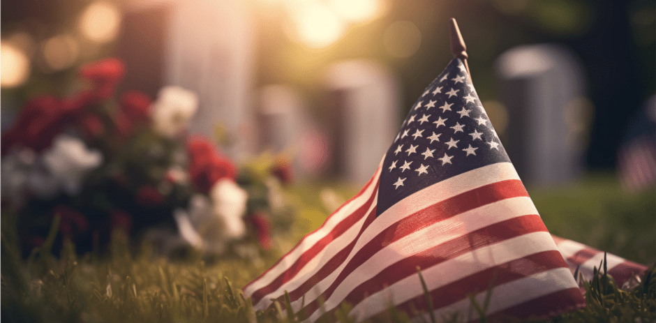 Sunset in a cemetery with American flag and bouquet of flowers