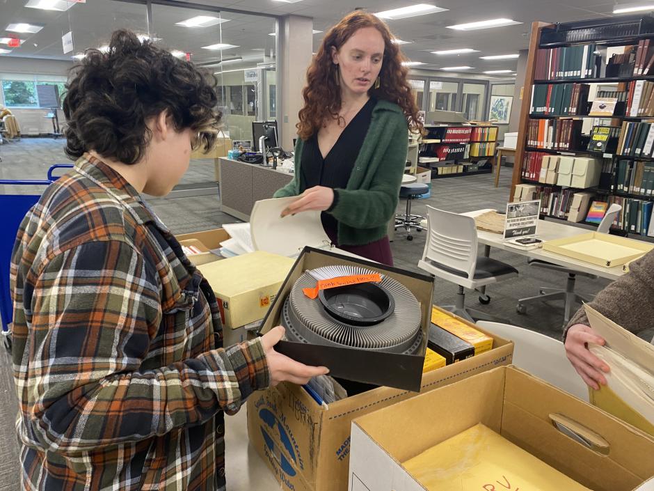 two people go through archival boxes