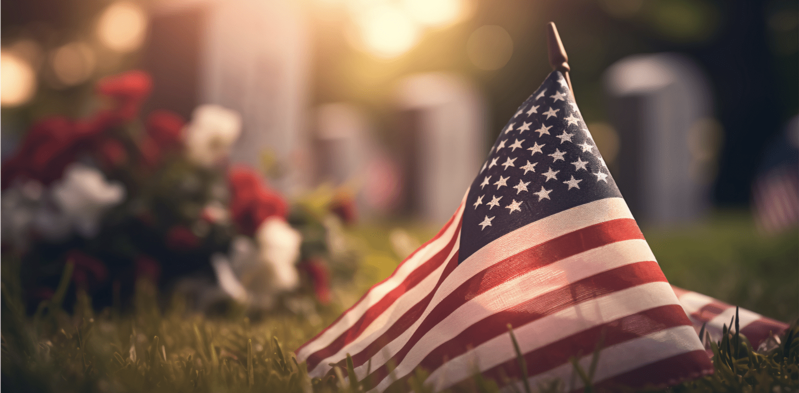 Sunset in a cemetery with American flag and bouquet of flowers