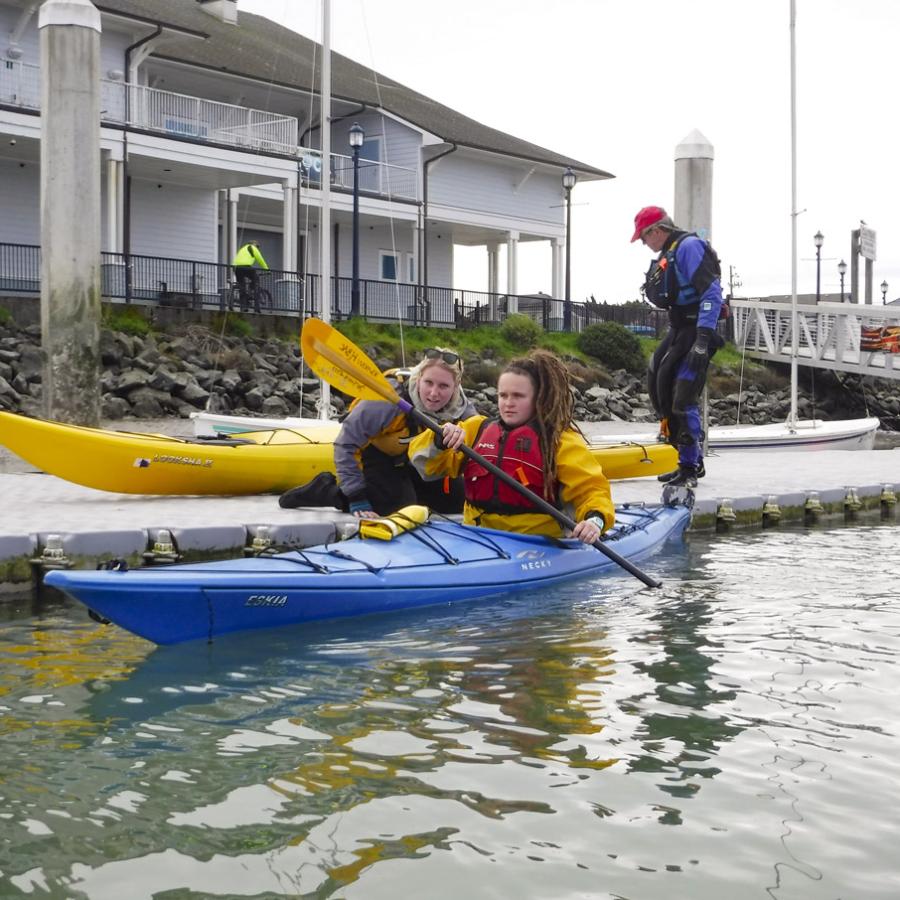 kayaker getting a private lesson from an instructor on the water
