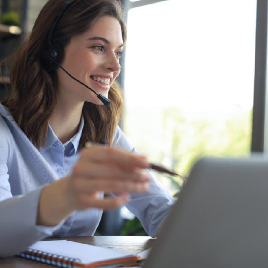 Woman wearing a headset, while working on computer