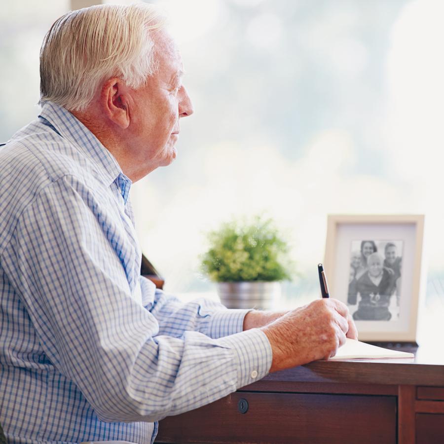 Older man writing at his desk