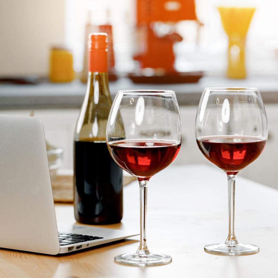 Wine glasses and bottle, next to notebook computer on kitchen counter