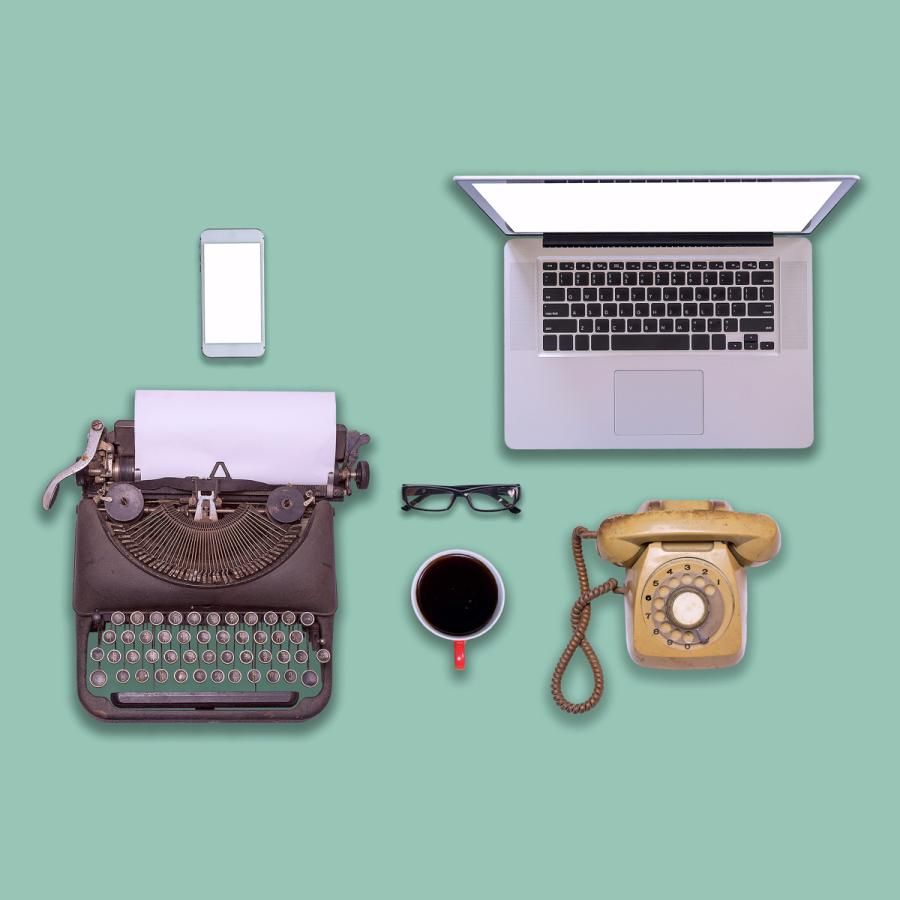 Old typewriter and rotary telephone, laptop computer and smartphone