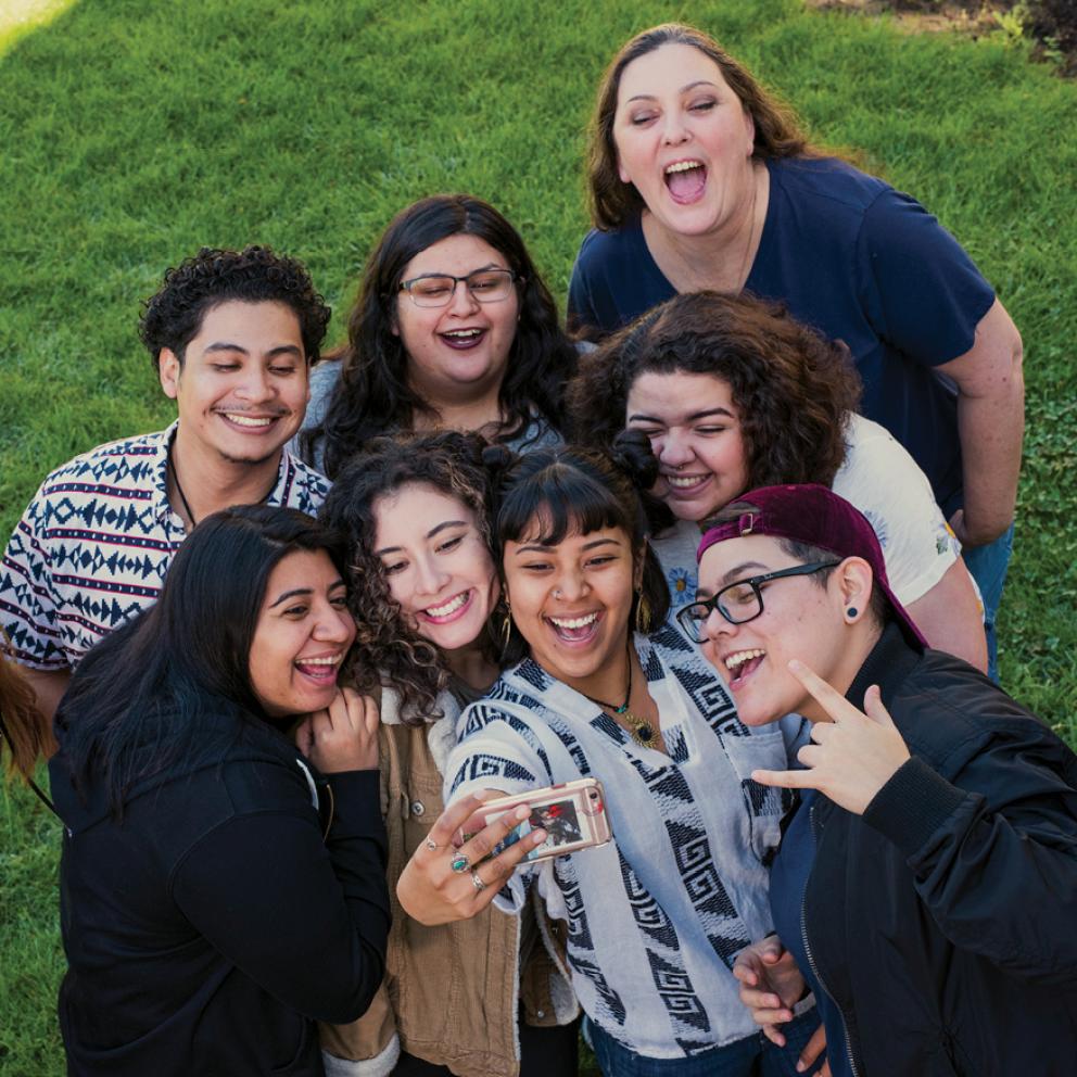 a diverse group of students smiling while taking a selfie