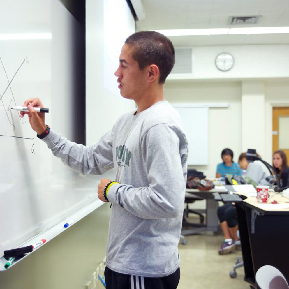 student writing on a whiteboard