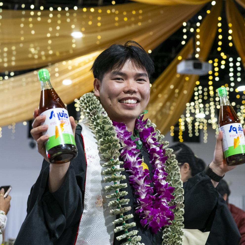 A graduate holding fish sauces