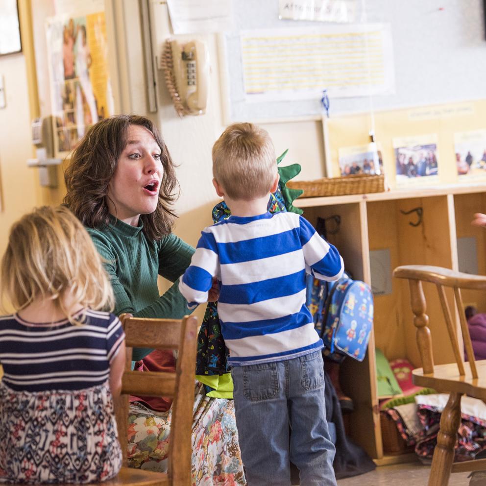 A student teacher talking to two small children