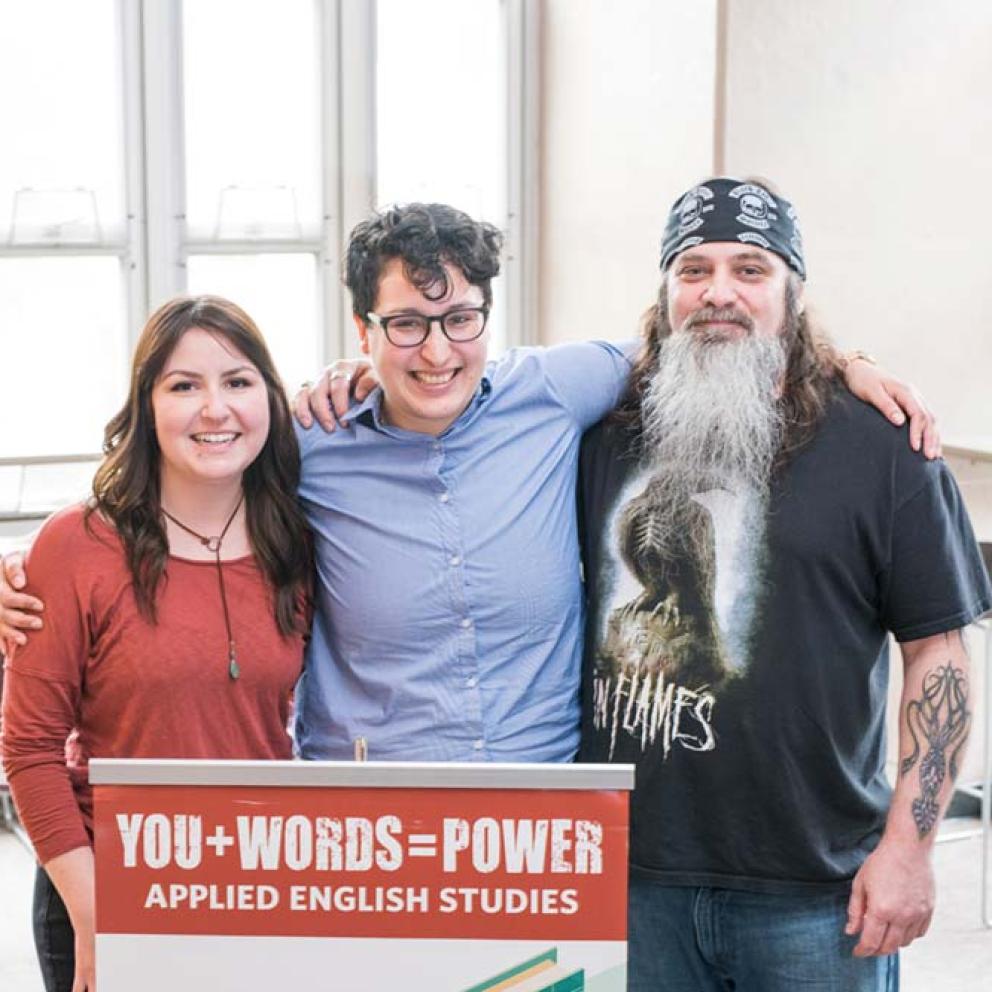 Students with professor holding sign you + words = power