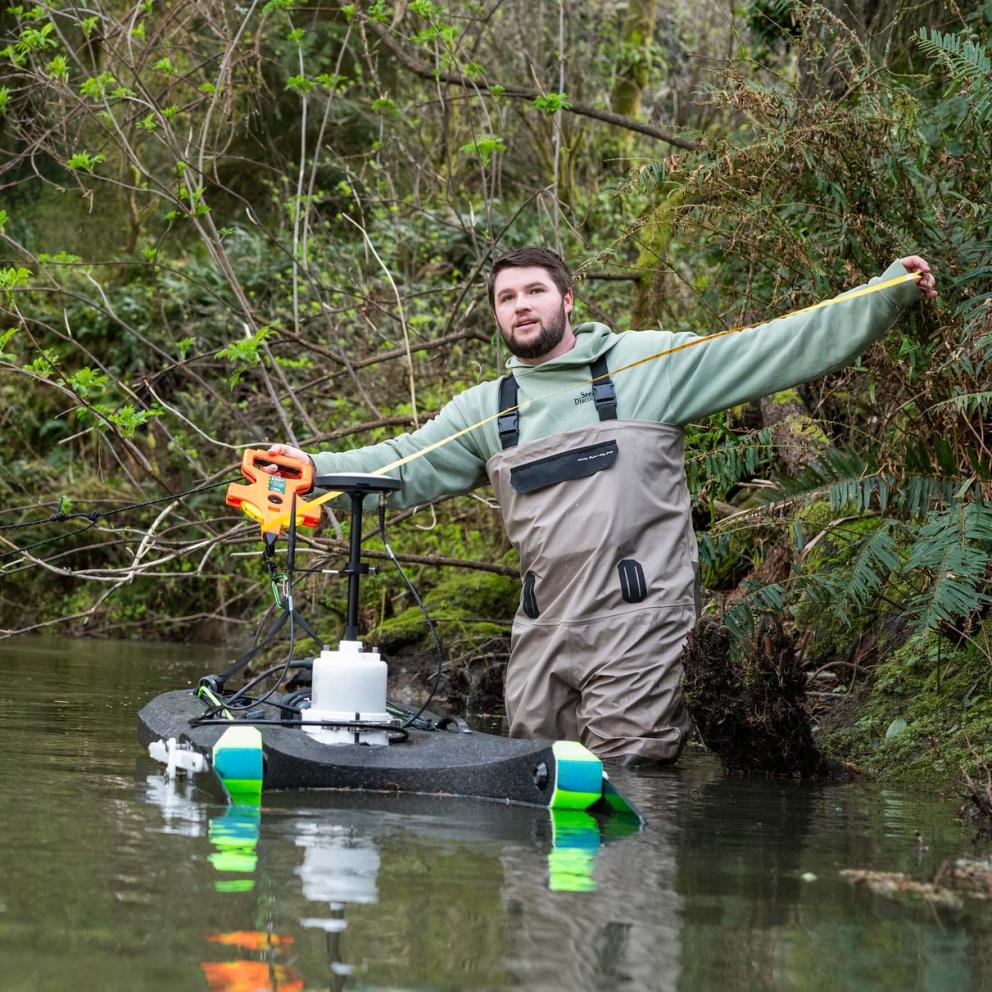 Student in waders in stream