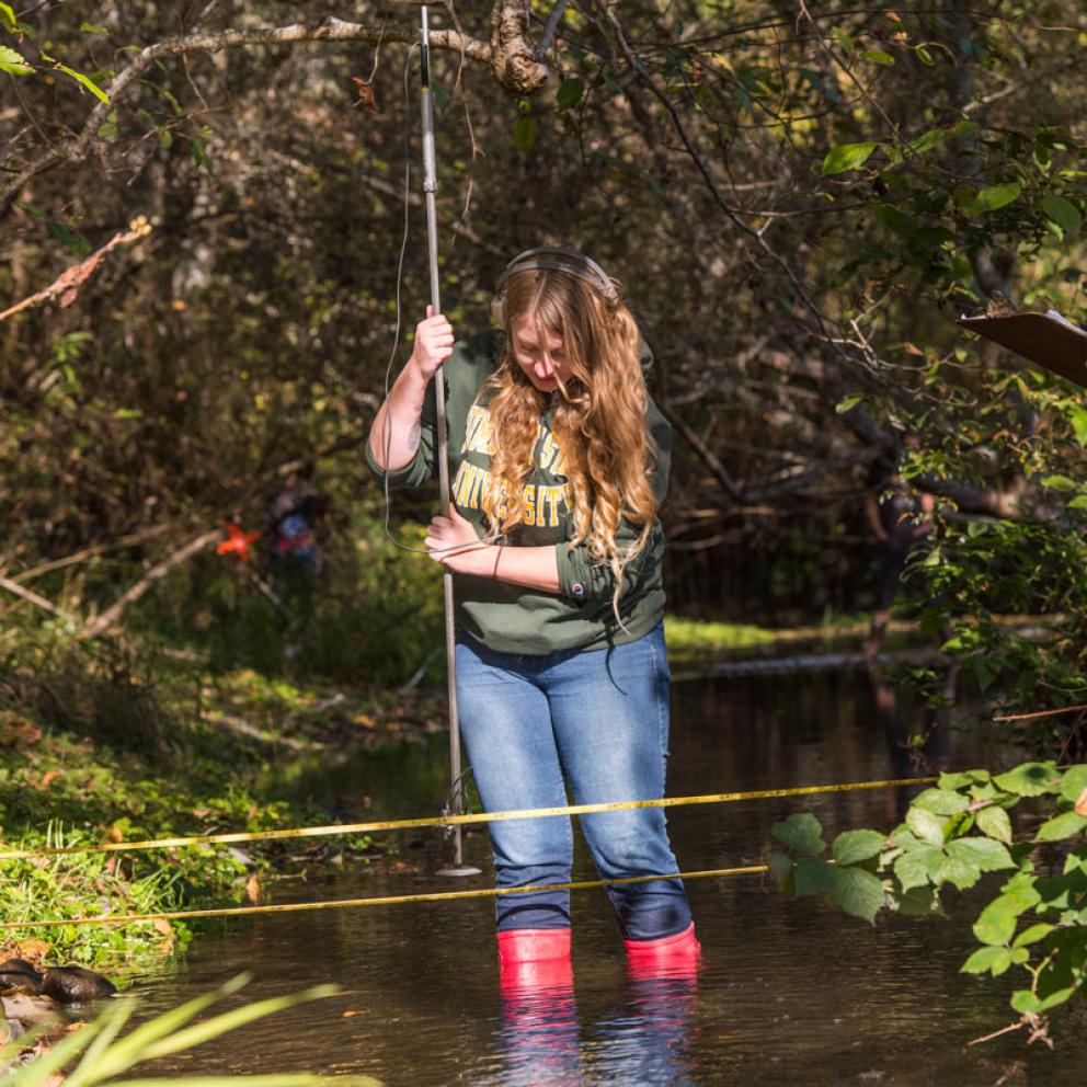 Student with a measuring tool in the water