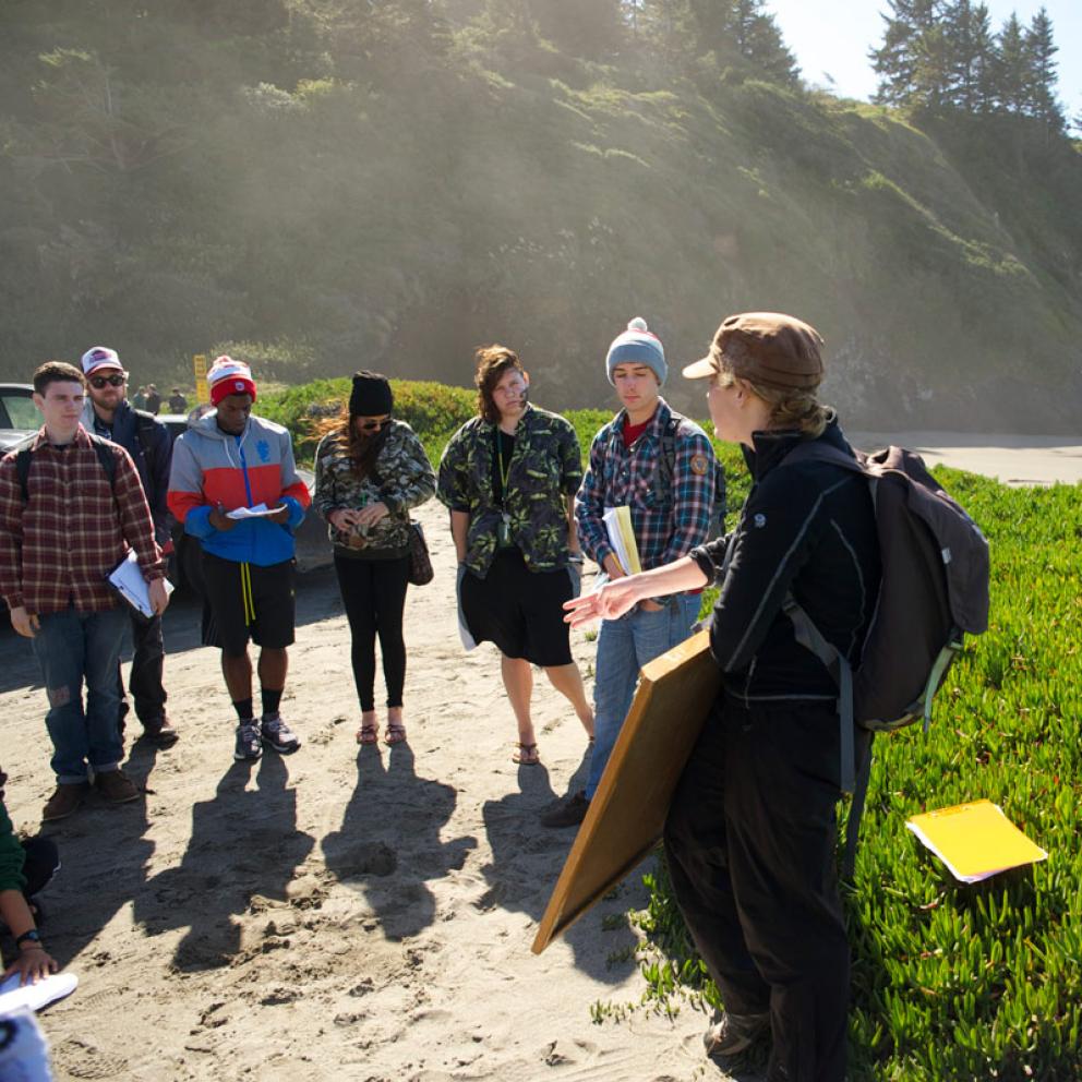 students standing at the beach in a half circle