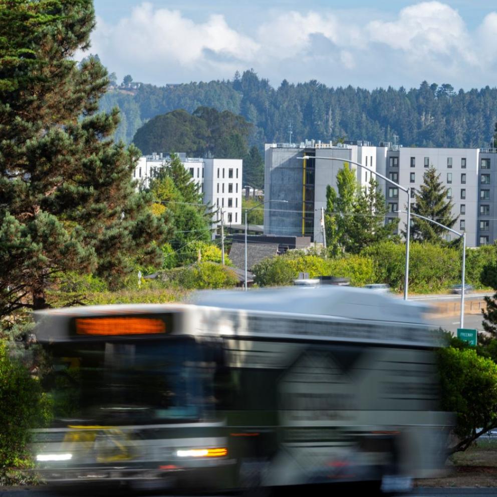 bus driving with apartments in the background