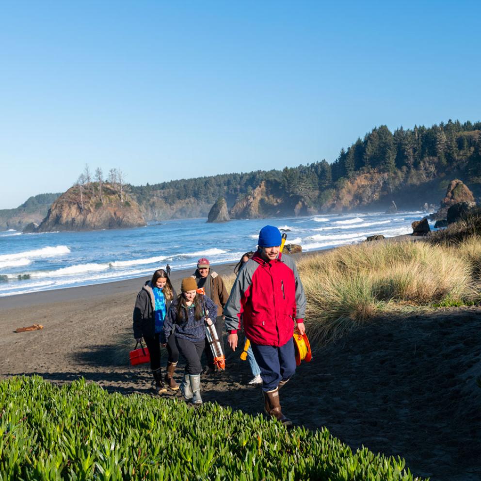 group of students walking back from the beach, ocean in the background