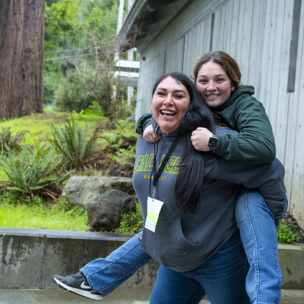 student giving another student a piggy back ride