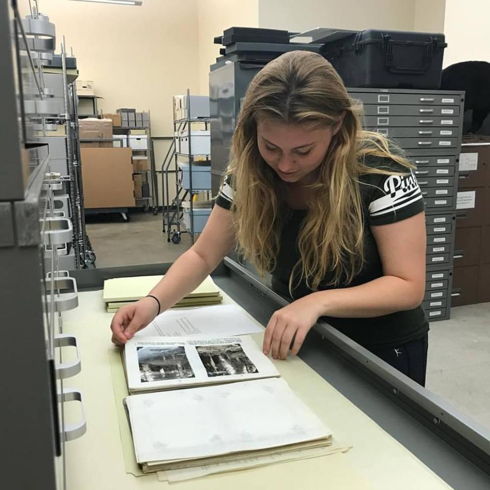 student archiving photos into. book
