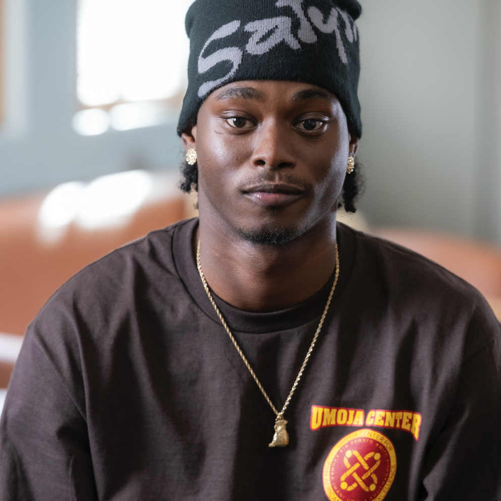 Ty poses with a black beanie and umoja staff shirt.