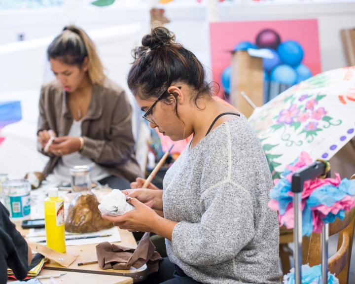 student painting a sculpture