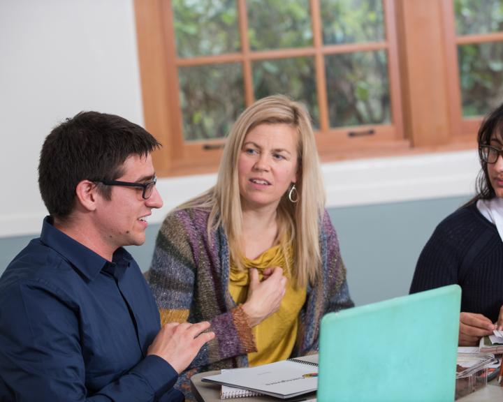 student on a computer talking to a professor