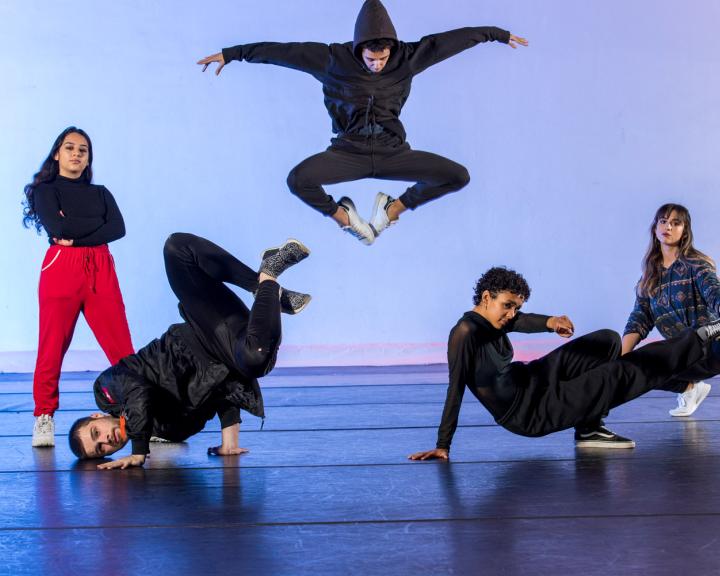 group of people doing hip hop dance style one student in the air