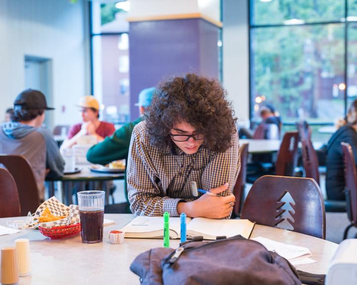 student studying at a table at the J