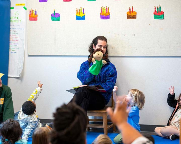 Teacher performing puppet show for class