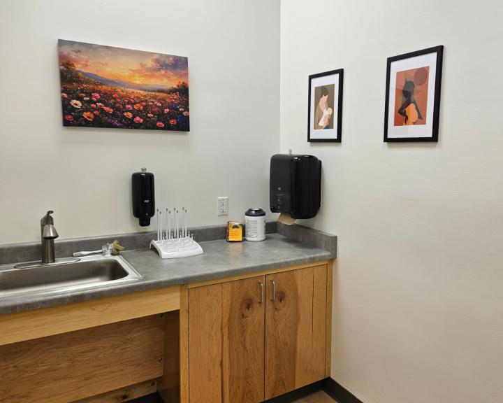 Sink and counter in lactation room with pictures on the wall