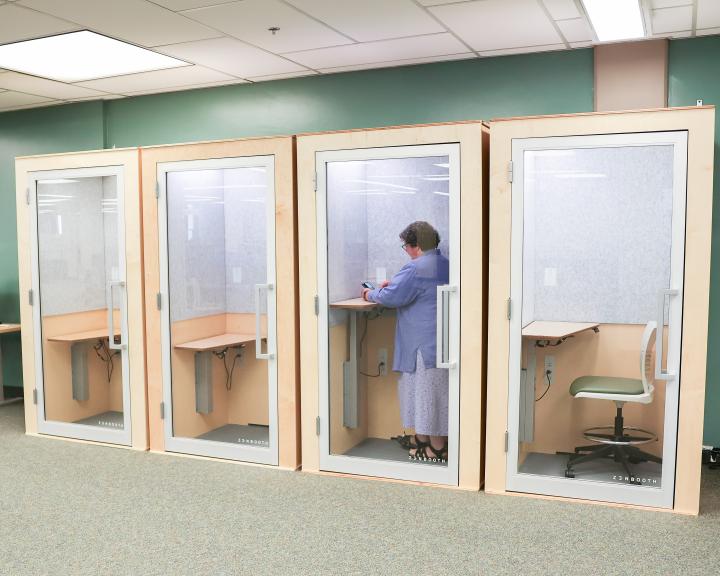 Four Audio booths with a person in one wearing purple