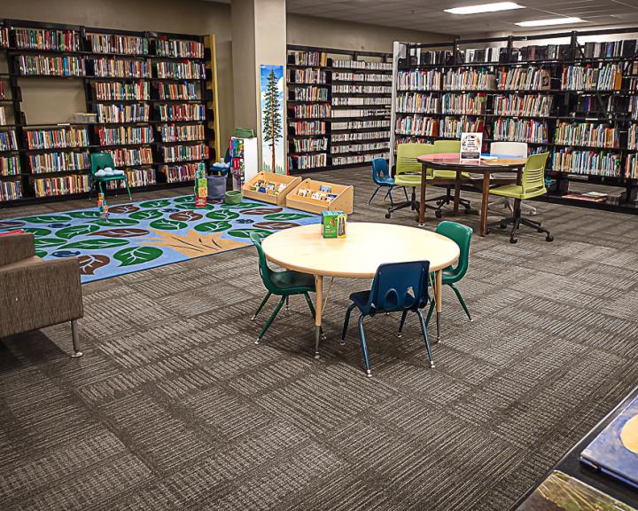 Space where young learners can read. Small tables and chairs and colorful carpet