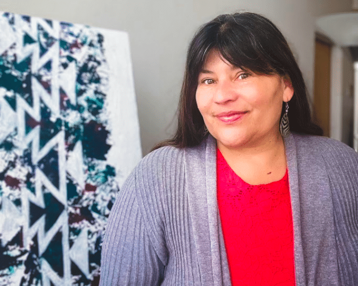 Adrienne standing by native artwork