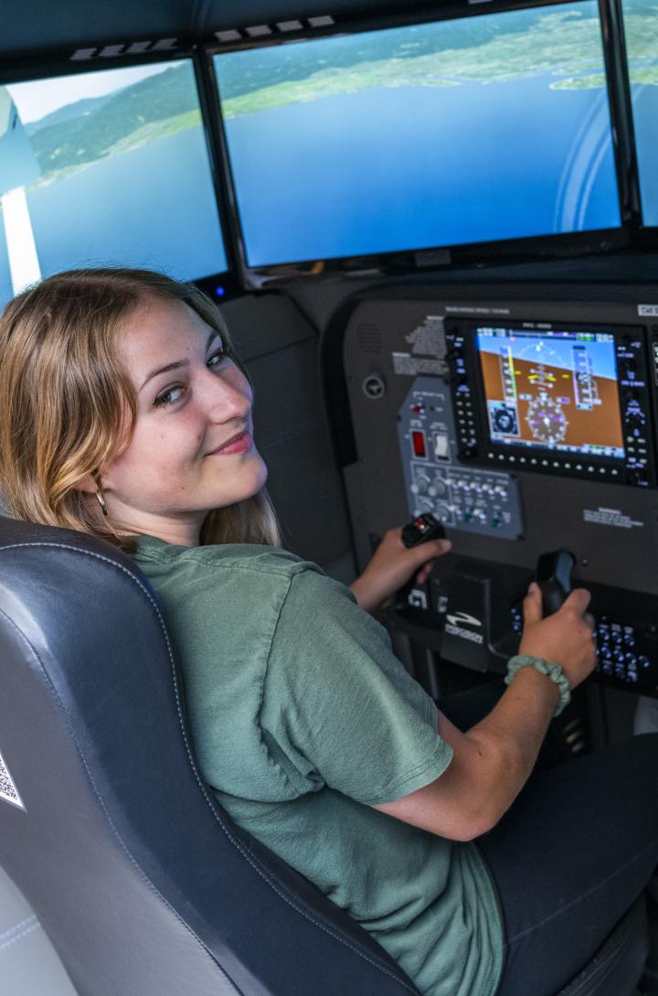 Student in pilot seat of flight sim