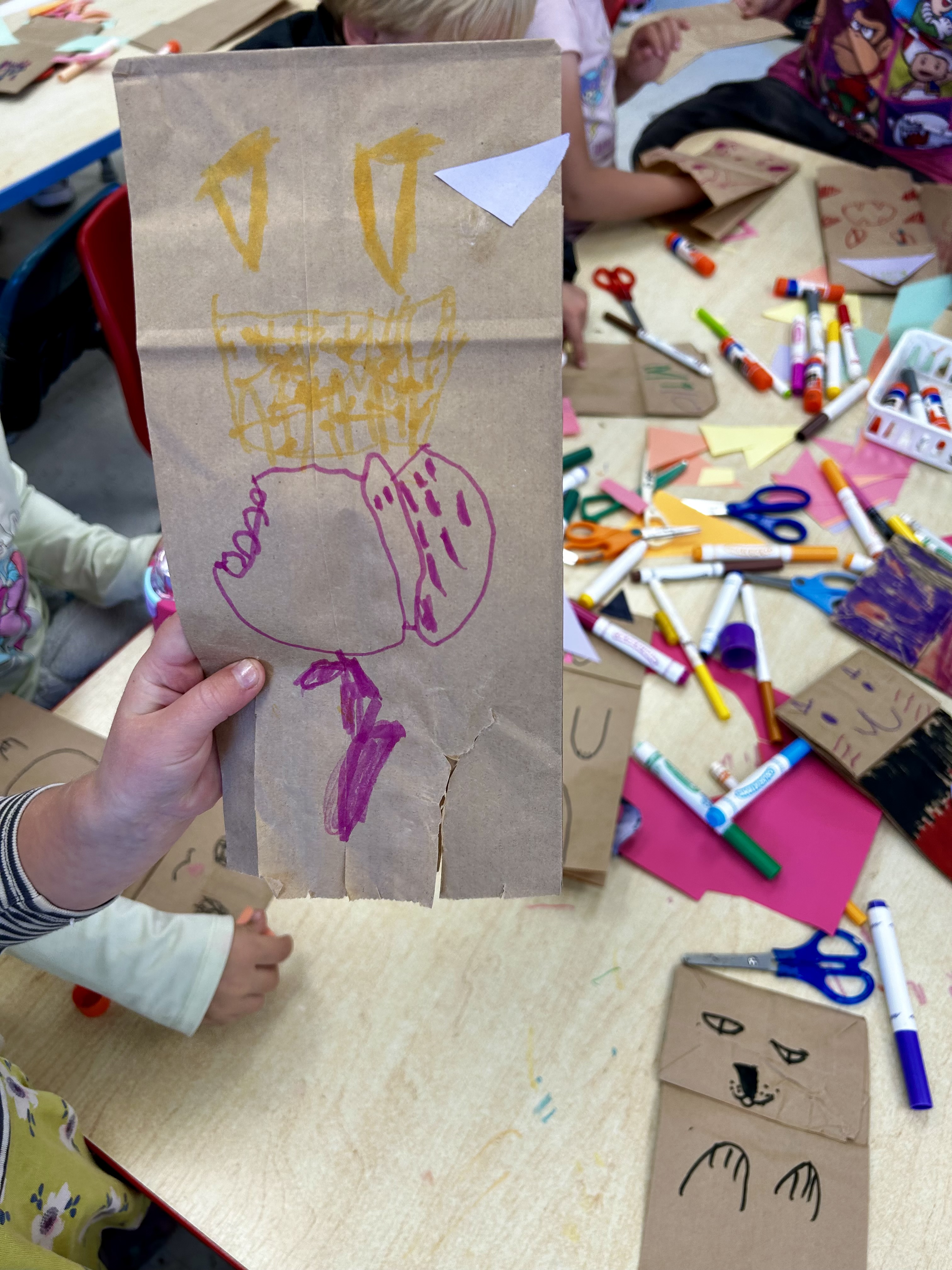 A student at Arcata Elementary holds up a paper bag puppet they created with the ART volunteeres (Fall 2024)