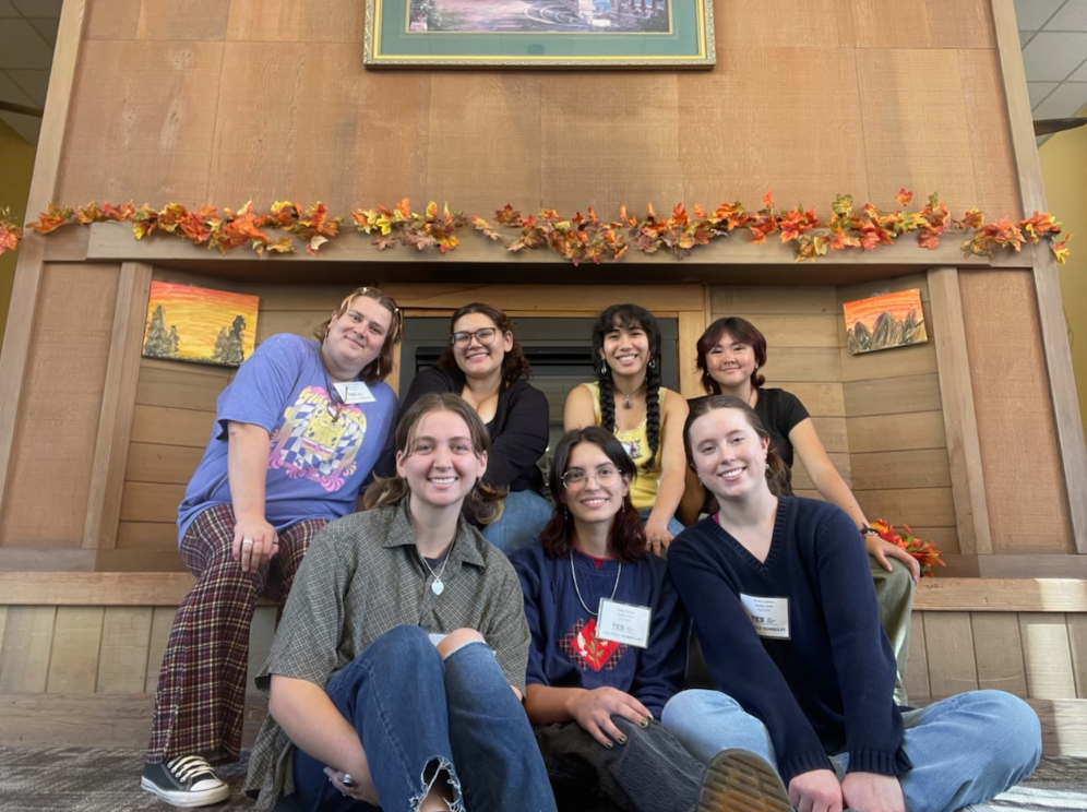 The Golden Years volunteer team sits together in front of the fireplace at Silvercrest (S25)