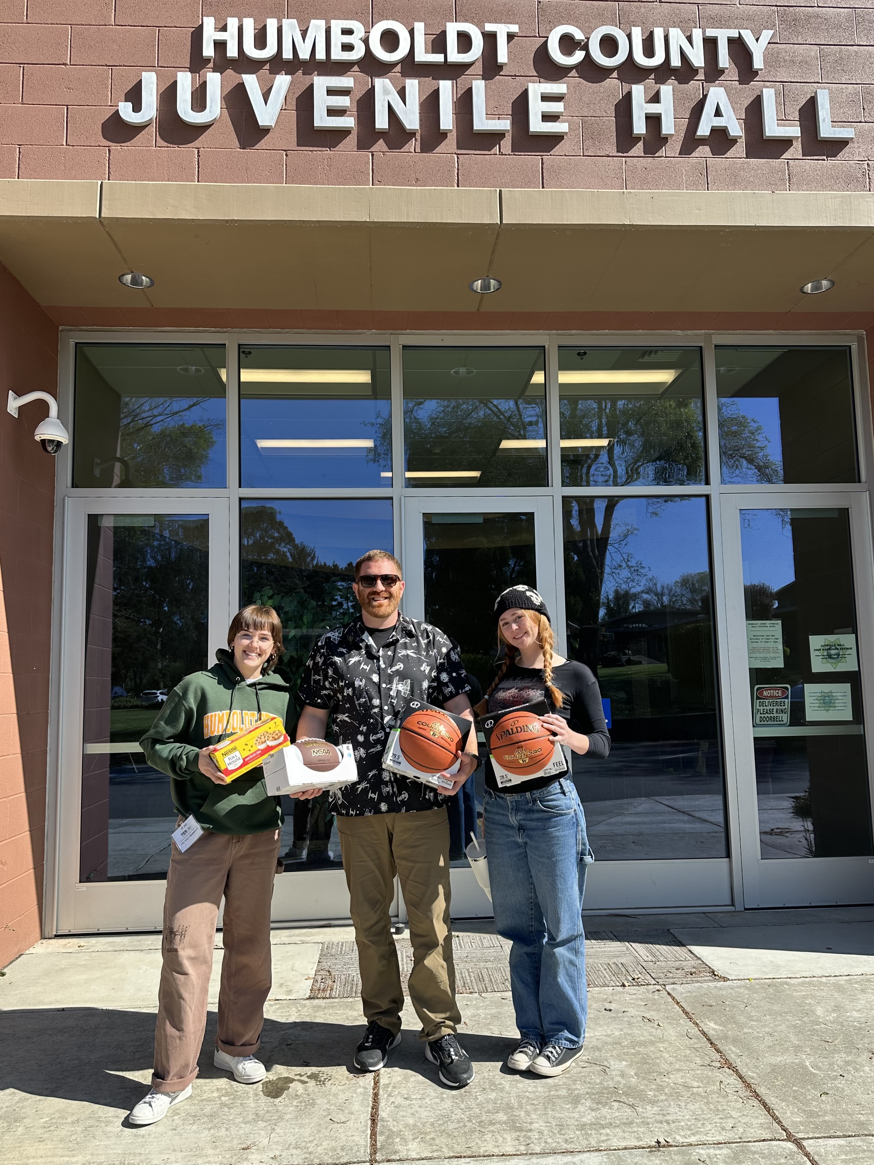 JHRP volunteers stand outside the Juvenile Hall with sports equipment gifts to celebrate their last visit of the semester.