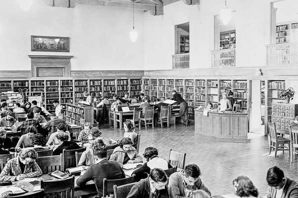 black and white photo of students in a library